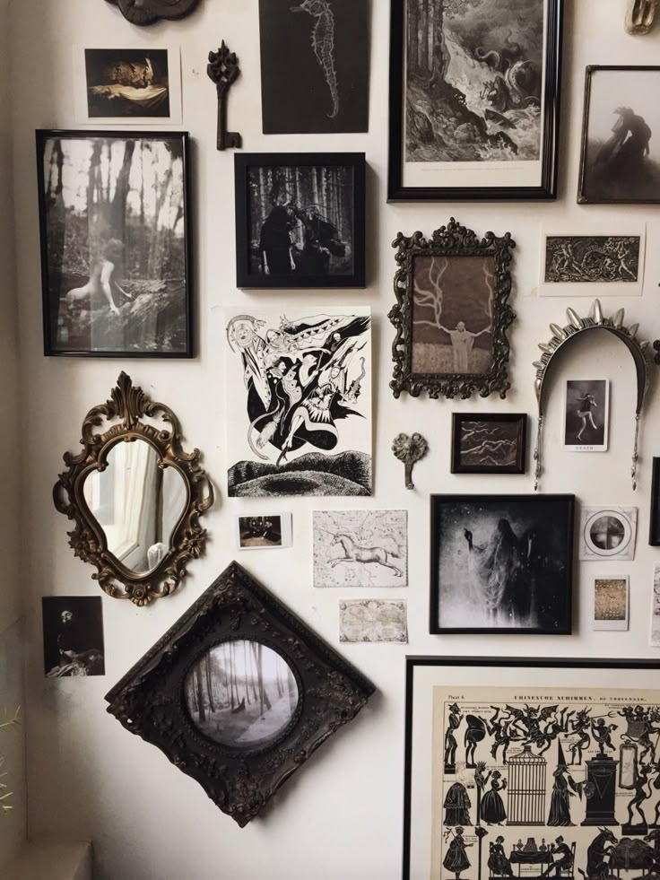 a wall covered in pictures and framed art on it's sidewall, with an ornate mirror hanging from the middle