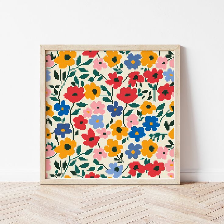 an art print with colorful flowers on it in a wooden frame against a white wall