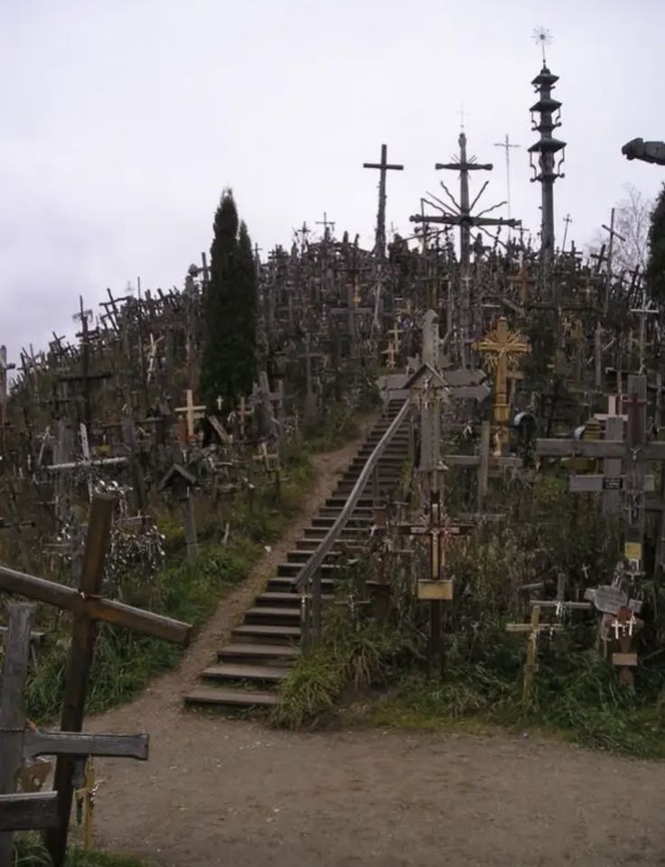 a cemetery with many crosses on it and stairs leading up to the top, all in different sizes