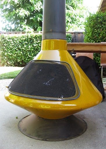 a yellow and black speaker sitting on top of a metal stand next to a bench