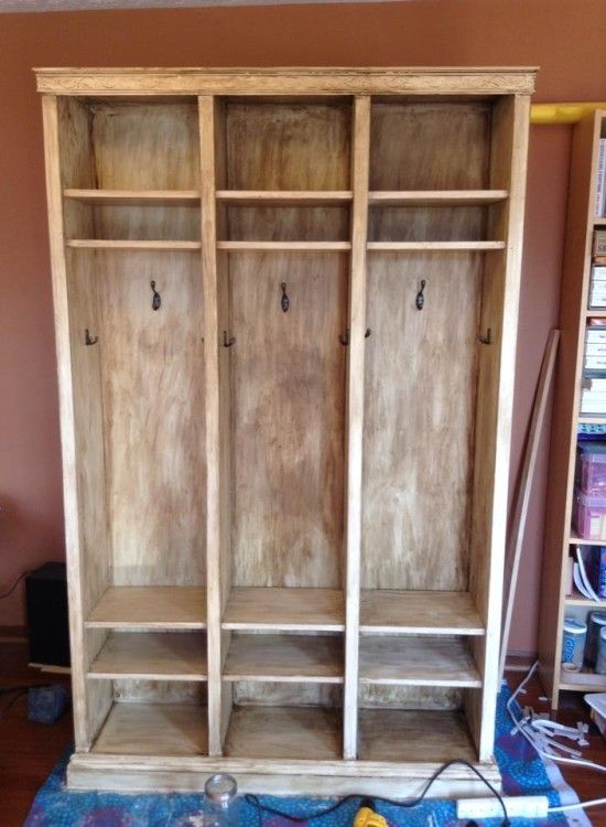 an empty wooden bookcase sitting on top of a blue rug