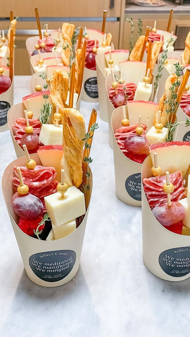 a table topped with cups filled with different types of food and snacks on top of each other