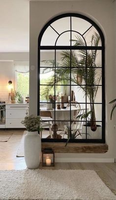 a living room filled with furniture and a large window next to a rug on top of a hard wood floor