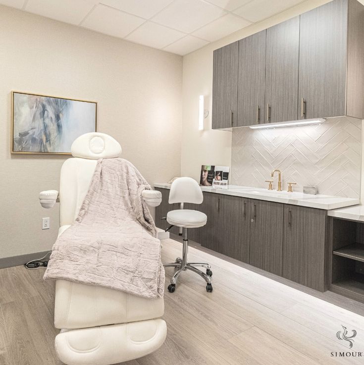 a dentist's chair with a blanket on it in the middle of a room