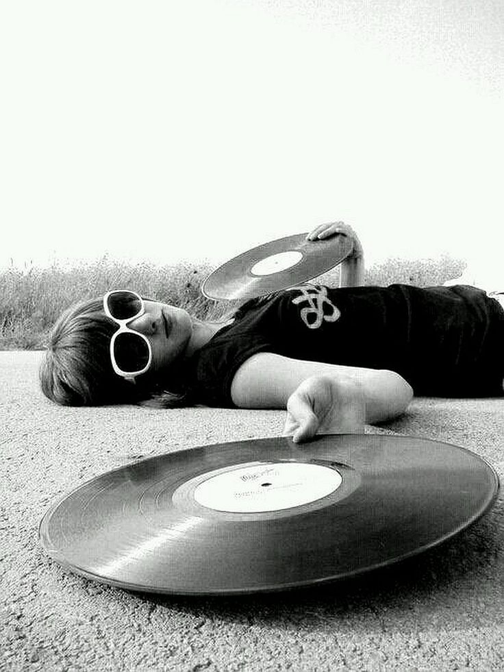 a woman laying on the ground next to a record