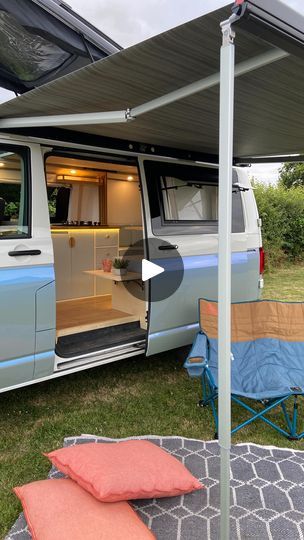 an old van is parked in the grass with it's door open and its bed pulled out