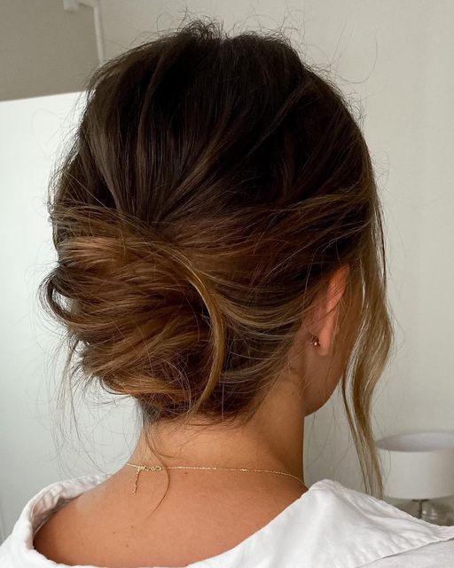 the back of a woman's head, with her hair in a low bun