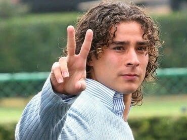 a young man making the peace sign with his hand