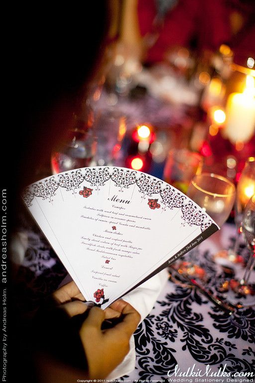 a person holding an umbrella over a table with wine glasses and candles in the background