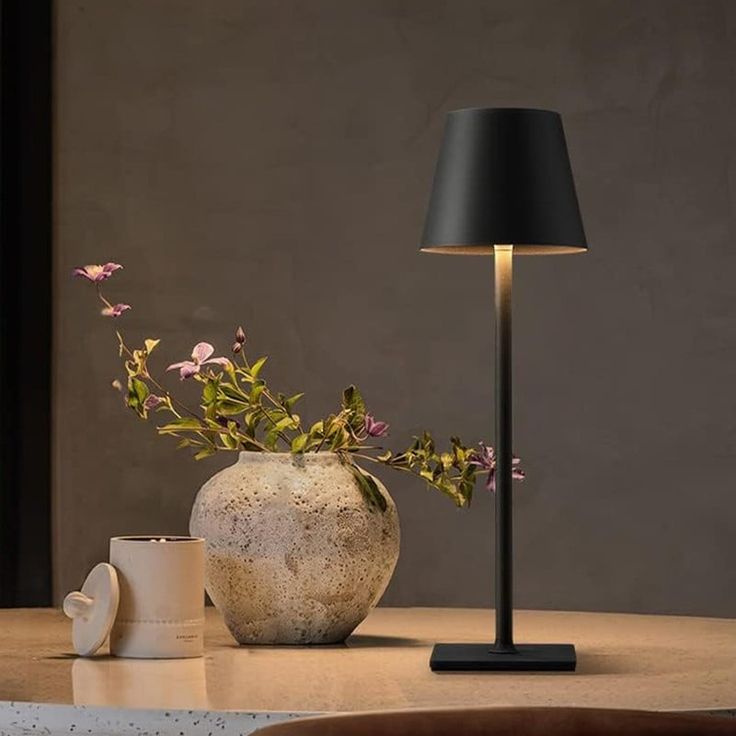 a table with a lamp and vase on it