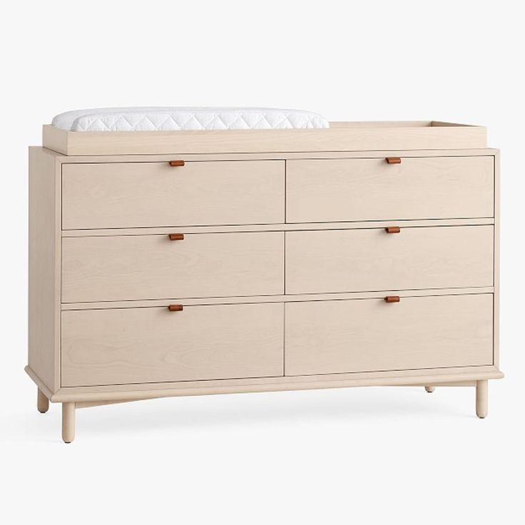 a white dresser with drawers and a baby crib in front of it on a white background