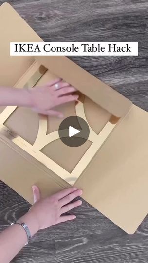 someone is opening up a cardboard table with their hands