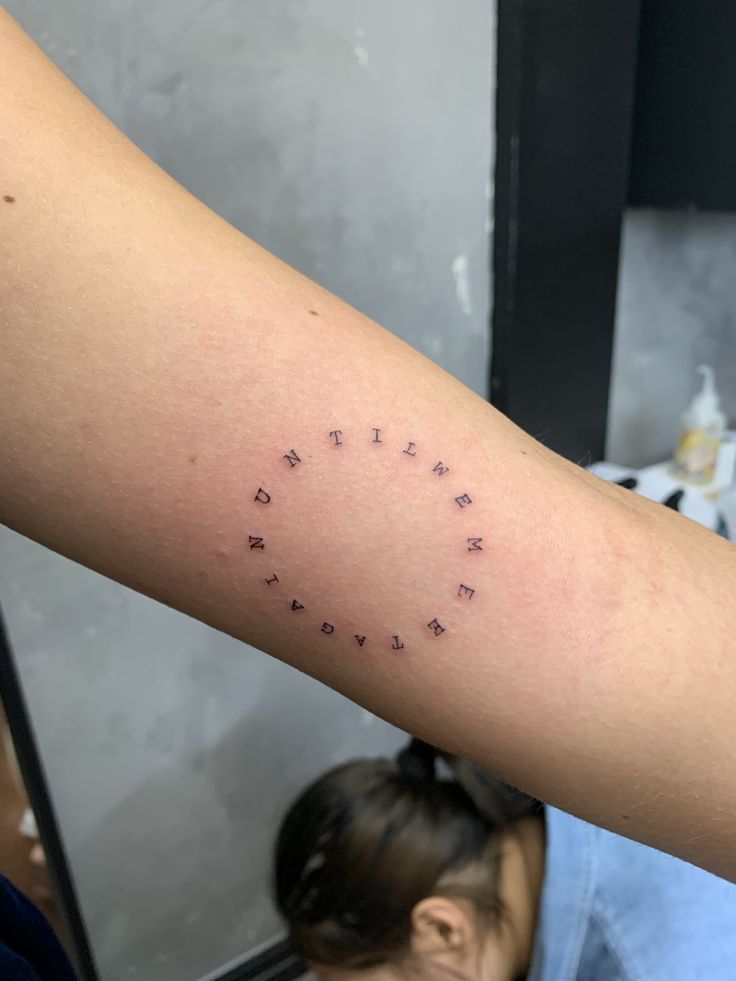 a woman's arm with the word love written in small cursive letters