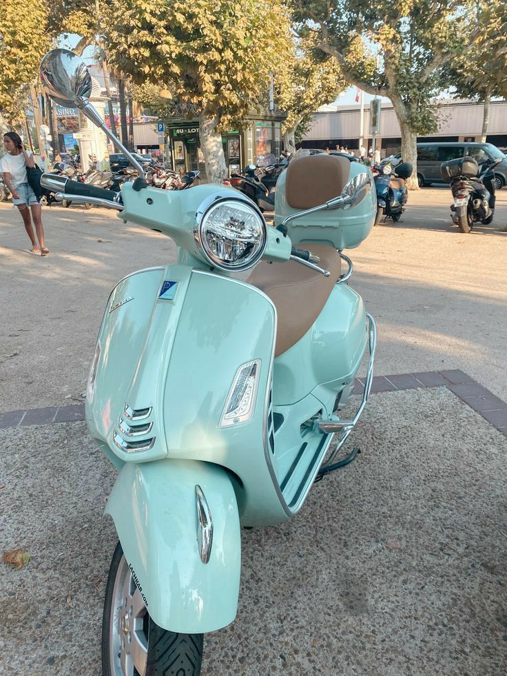 a light blue scooter is parked on the street