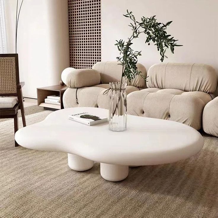 a white coffee table sitting on top of a carpeted floor next to a couch