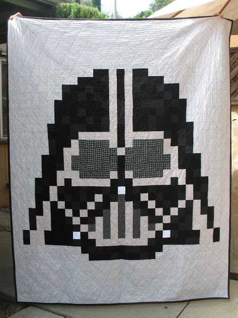 a star wars themed quilt is displayed on a tablecloth with an image of darth vader's face