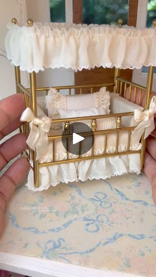 a miniature baby crib is being held by someone