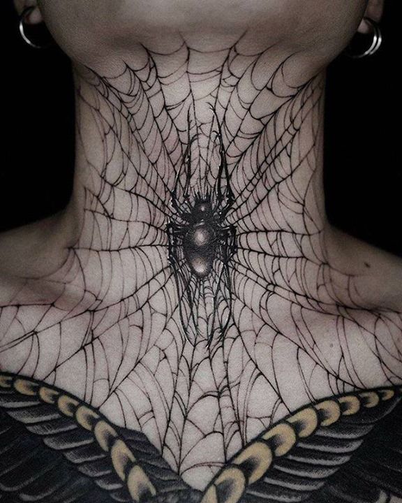 a woman's neck is covered with spider webs and an intricate design on her chest