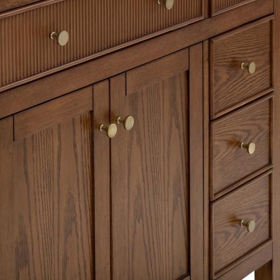 a wooden cabinet with brass knobs and drawers