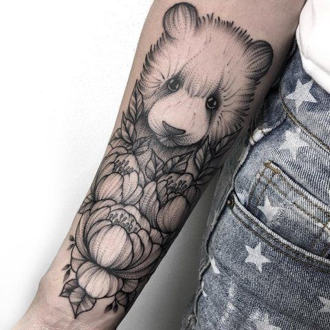 a bear and flowers tattoo on the arm