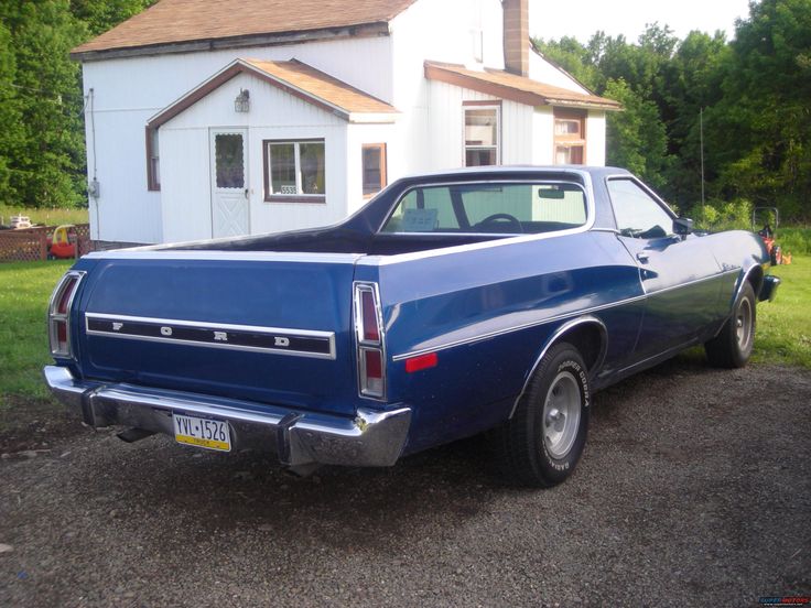 a blue car parked in front of a house