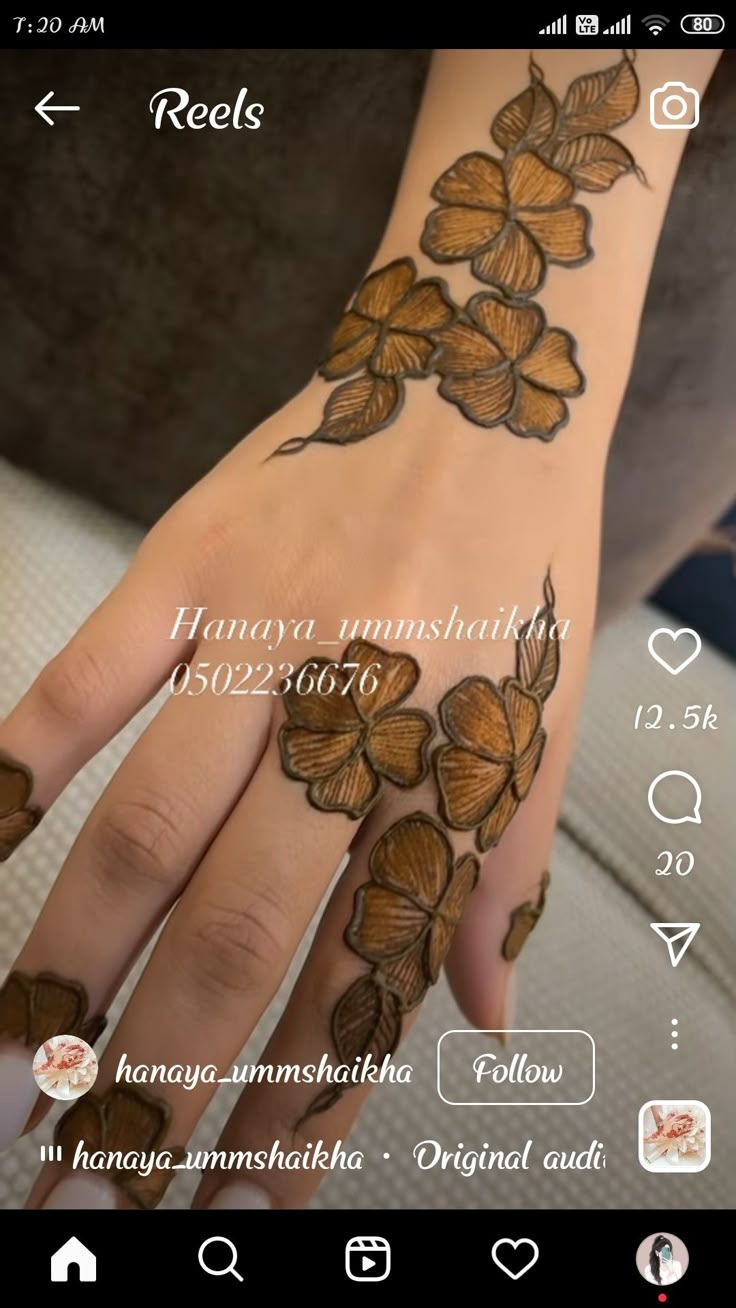 hendi tattoos on the palm of a woman's hand with flowers and leaves