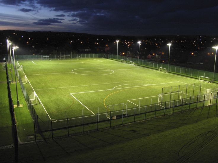 an empty soccer field lit up at night