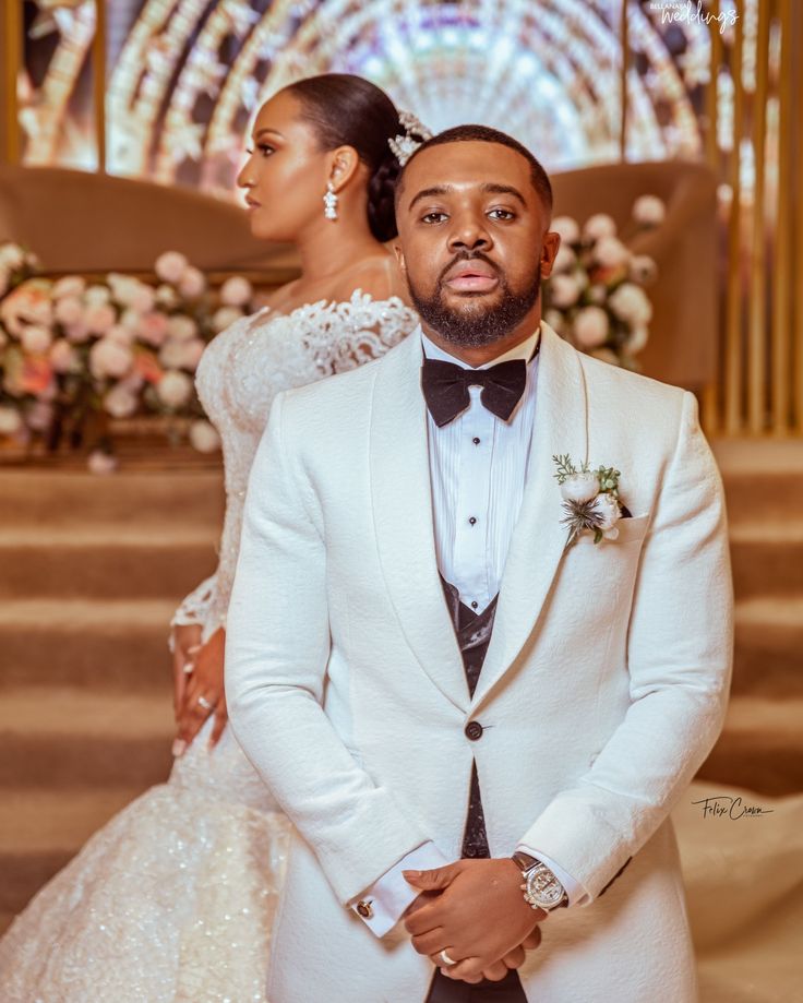 a man in a tuxedo standing next to a woman