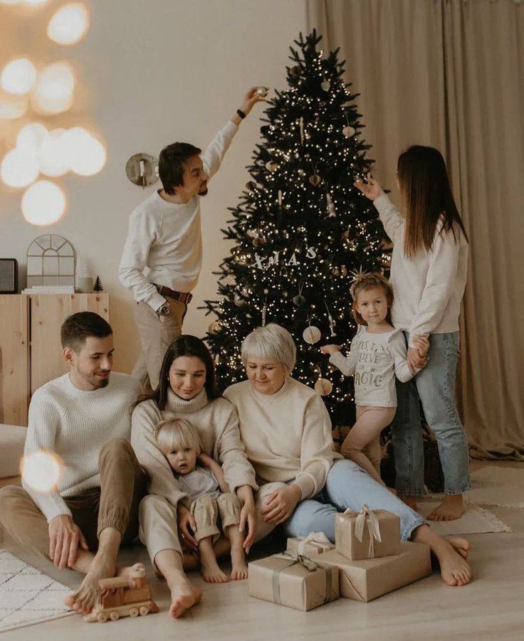 a family sitting in front of a christmas tree