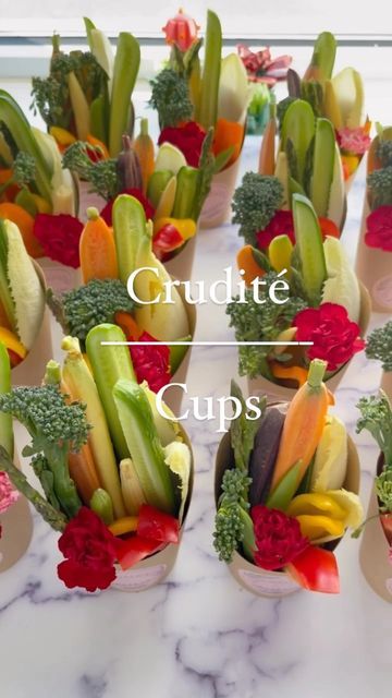 a table topped with cups filled with different types of vegetables