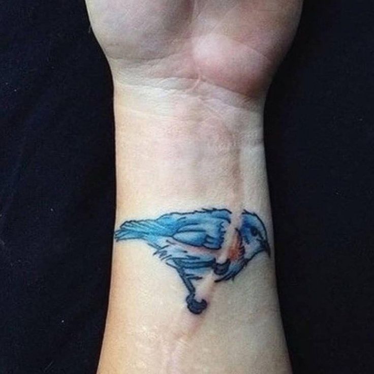 a blue bird tattoo on the wrist