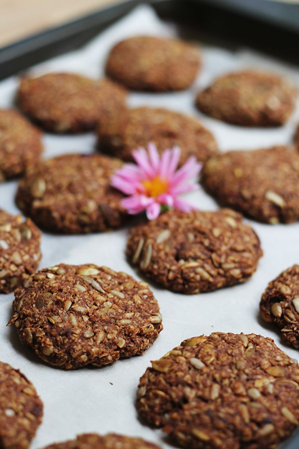 some cookies are on a baking sheet with a pink flower in the middle and one is out