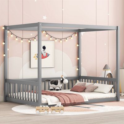 a child's bedroom with pink walls and white furniture, including a gray canopy bed