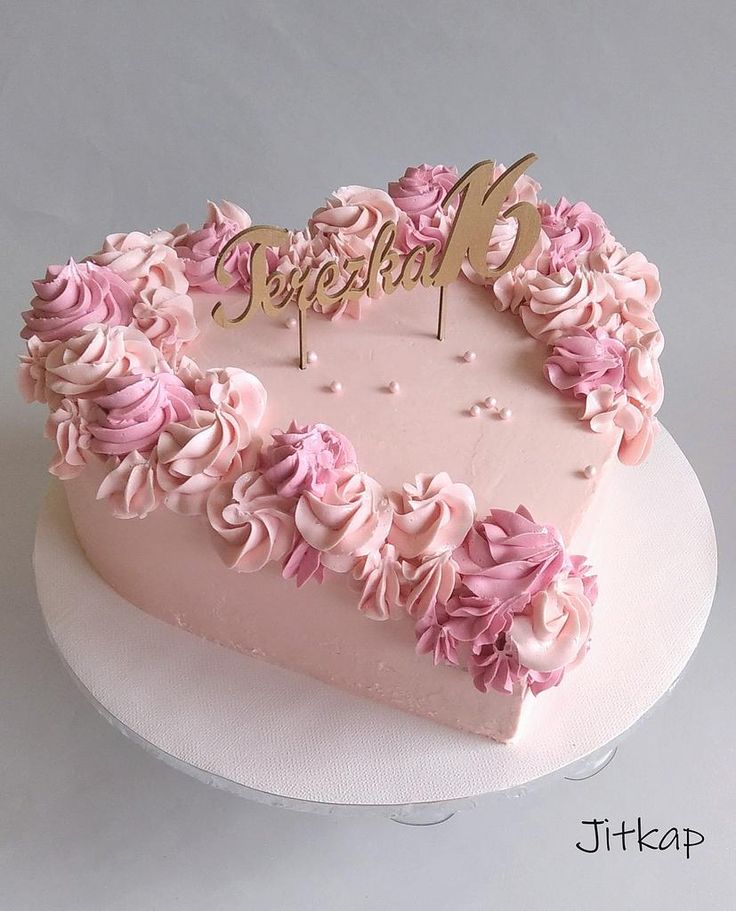 a heart shaped cake with pink frosting and flowers