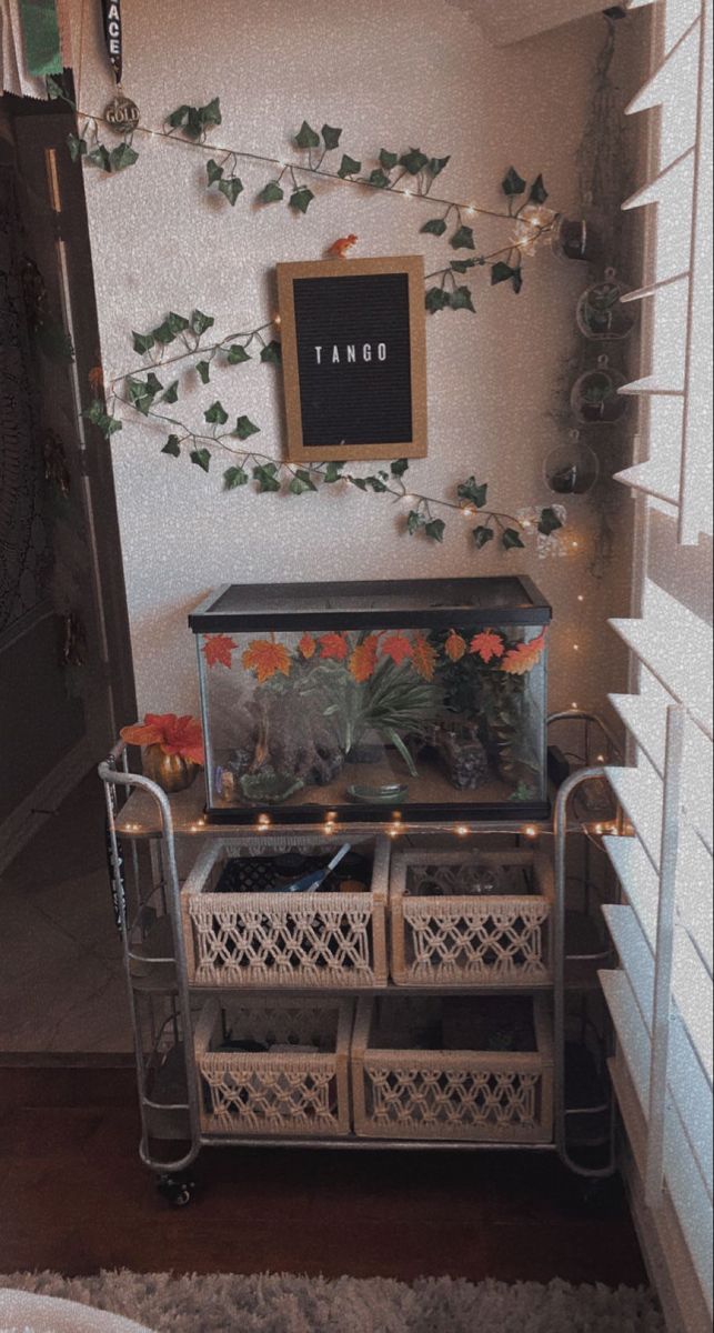 an old dresser with plants and candles on it in a room that is decorated with string lights