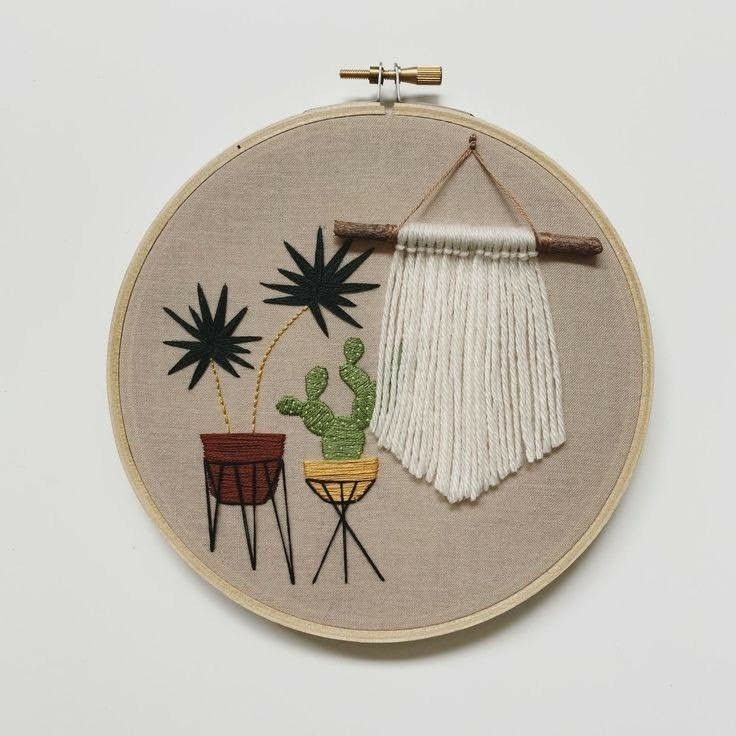 an embroidered wall hanging with various potted plants and cactuses on it's side