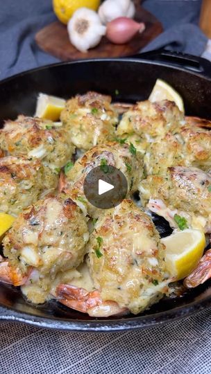 a pan filled with food on top of a table next to lemons and garlic