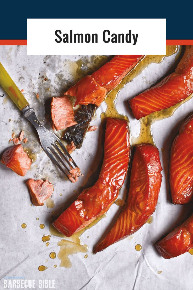 salmon on parchment paper with fork and knife next to it, surrounded by other fish