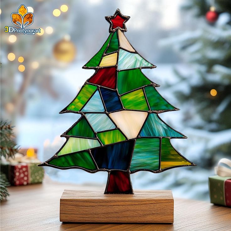 a stained glass christmas tree sitting on top of a table