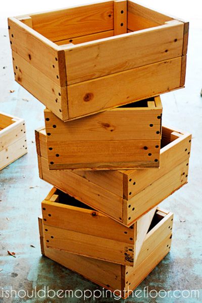 four wooden boxes stacked on top of each other in the middle of a floored area