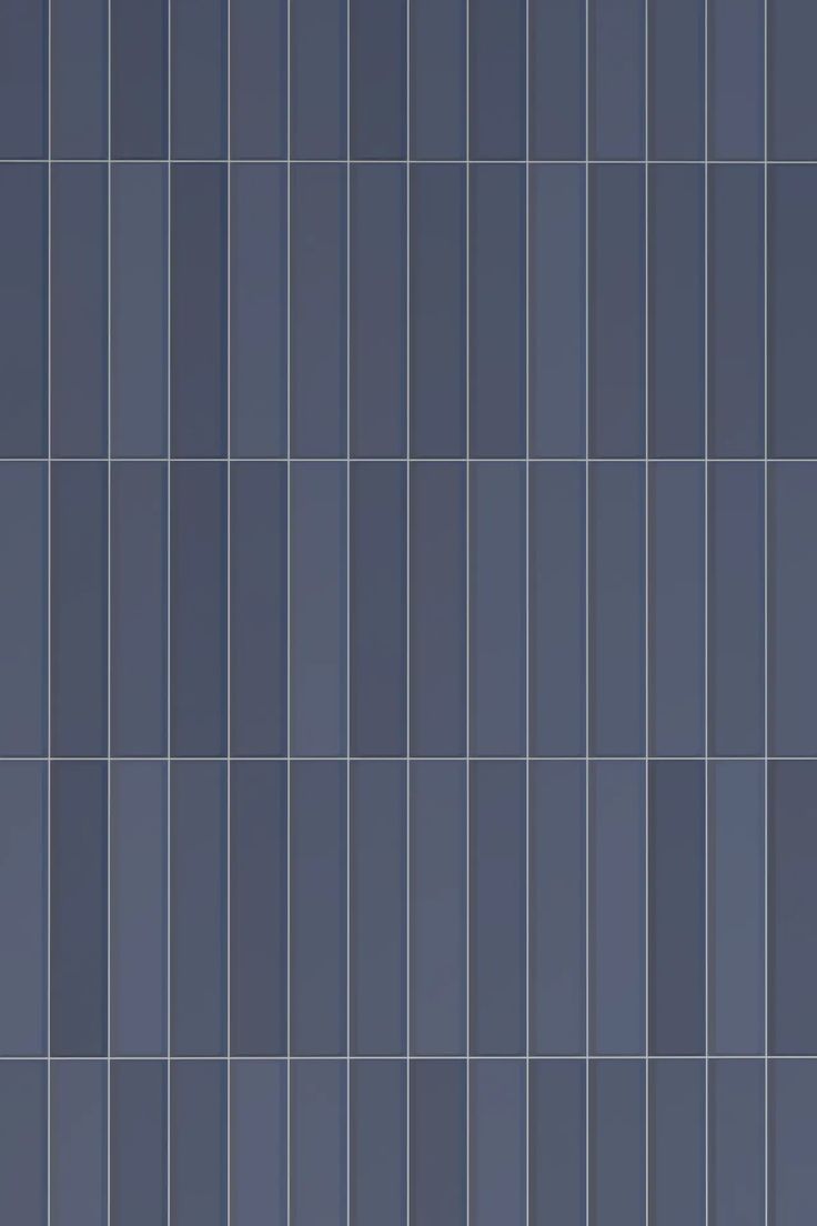 a blue tiled wall with vertical lines