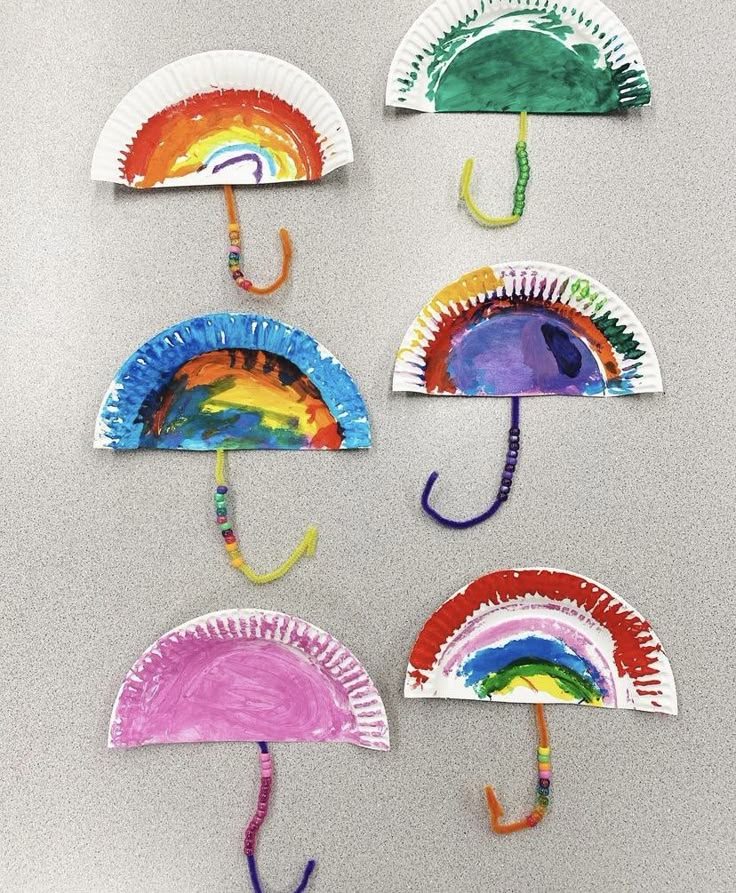 paper plate umbrellas made to look like they are painted with different colors and shapes