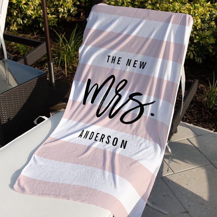 a pink and white towel that says the new mrs on it sitting on a chair