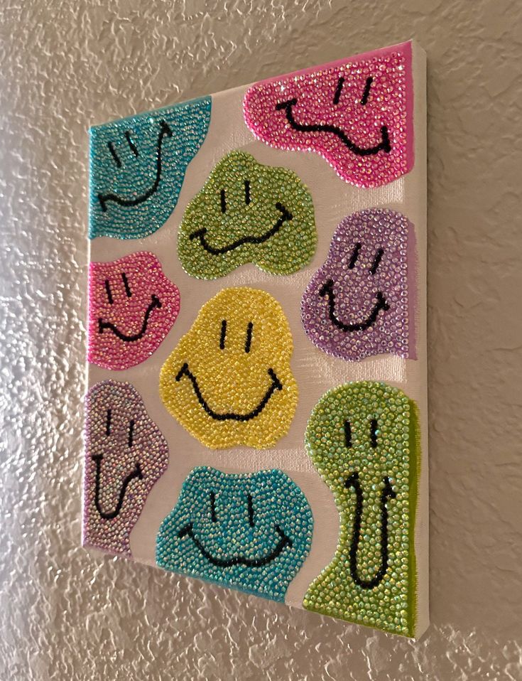 a painting on the wall with many different colored smiley faces and hands painted on it