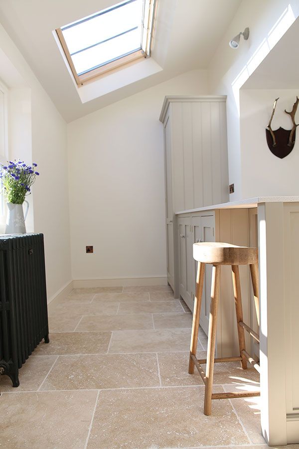 a kitchen with an island and stools in it's center area, under a skylight