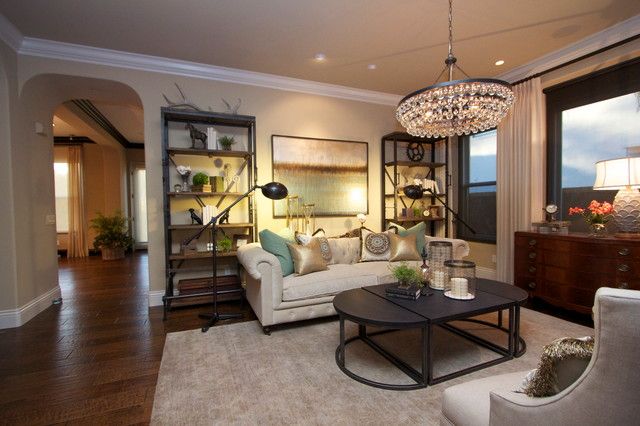 a living room filled with furniture and a chandelier hanging over the top of it