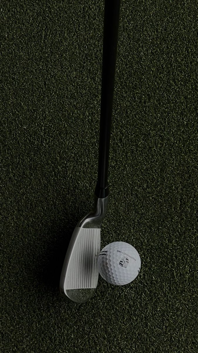 a golf ball and club laying on the ground next to each other in front of a tee