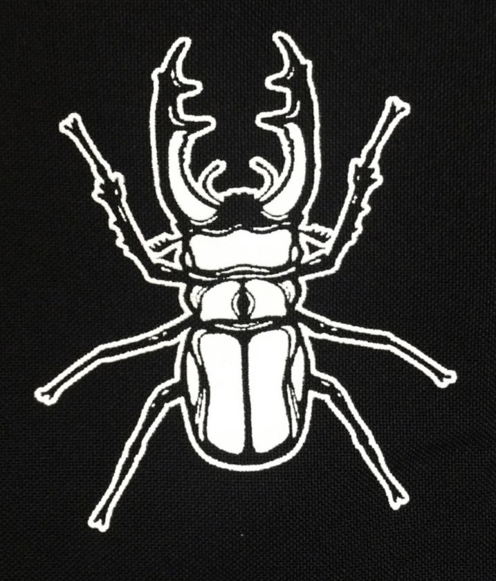 a black and white beetle with antlers on it's back side, in front of a dark background