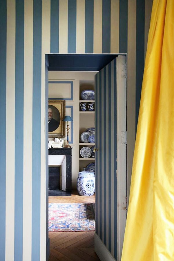 an open door leading into a room with blue and white striped walls