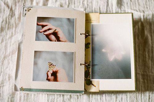 an open photo book with pictures of hands holding something in the middle and on top